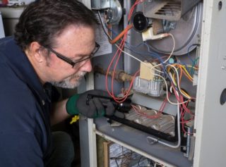One of our technicians makes needed repairs to a gas furnace in order to restore heating to a local home.